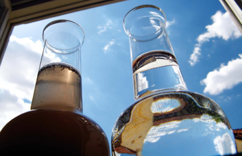 Two bottles standing side by side, one with unfiltered water, the other with filtered water